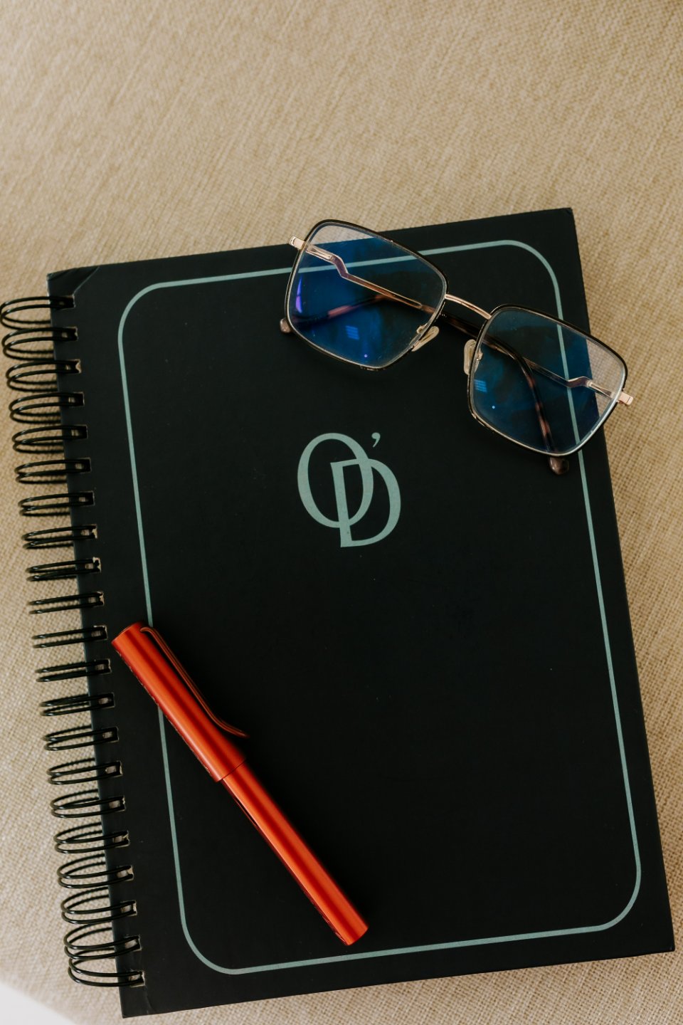 Caderno O'Donnell, óculos e caneta